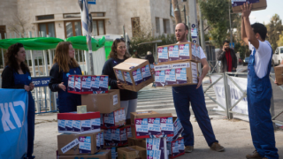 Activists from the V-15 ( victory in 2015) organization at a protest outside PM Netanyahu's residence in Jerusalem, where they set up a mock move of boxes. Photo: Miriam Alster/Flash90