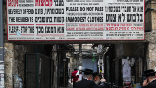 Caption: Ultra-Orthodox men near a 'modesty' sign in Jerusalem's Mea Shearim neighborhood. Photo: Nati Shohat/Flash90