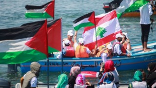 Palestinians hold flags as they ride a boat during a rally marking the 5th anniversary of the Mavi Marmara Gaza flotilla, at the seaport of Gaza City May 31, 2015. Photo: Aaed Tayeh/Flash90