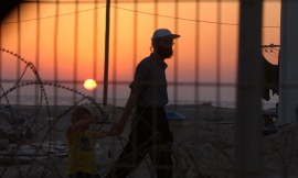 A man walking with child at sunset in Sayarat Hayam in Gush Katif. August 5, 2005. Photo: Flash90.